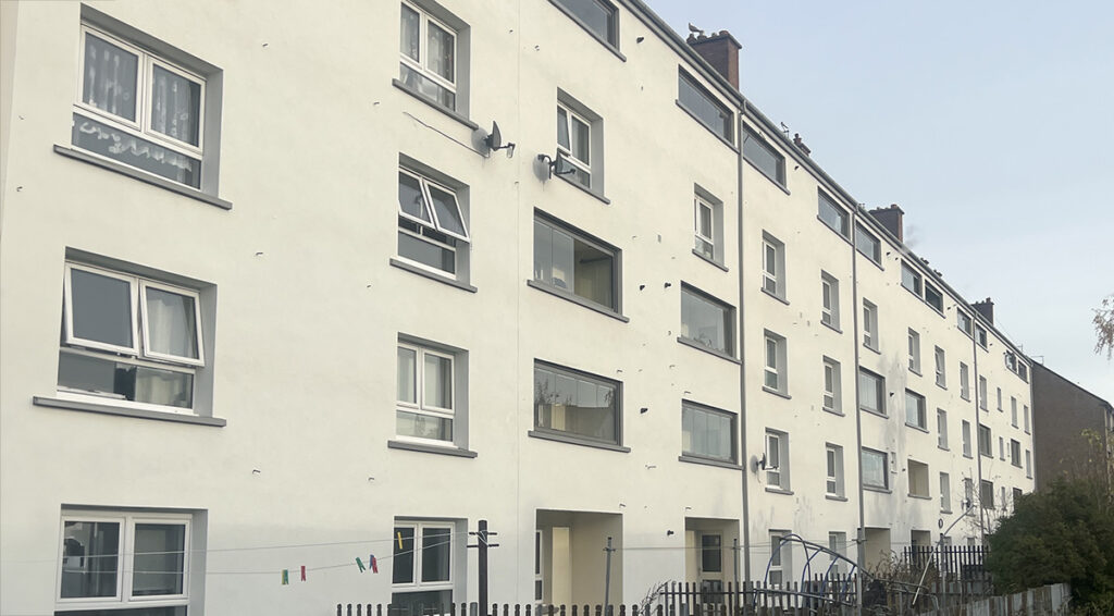 Magdalene Drive, Edinburgh: white rendered block of flats seen along its length