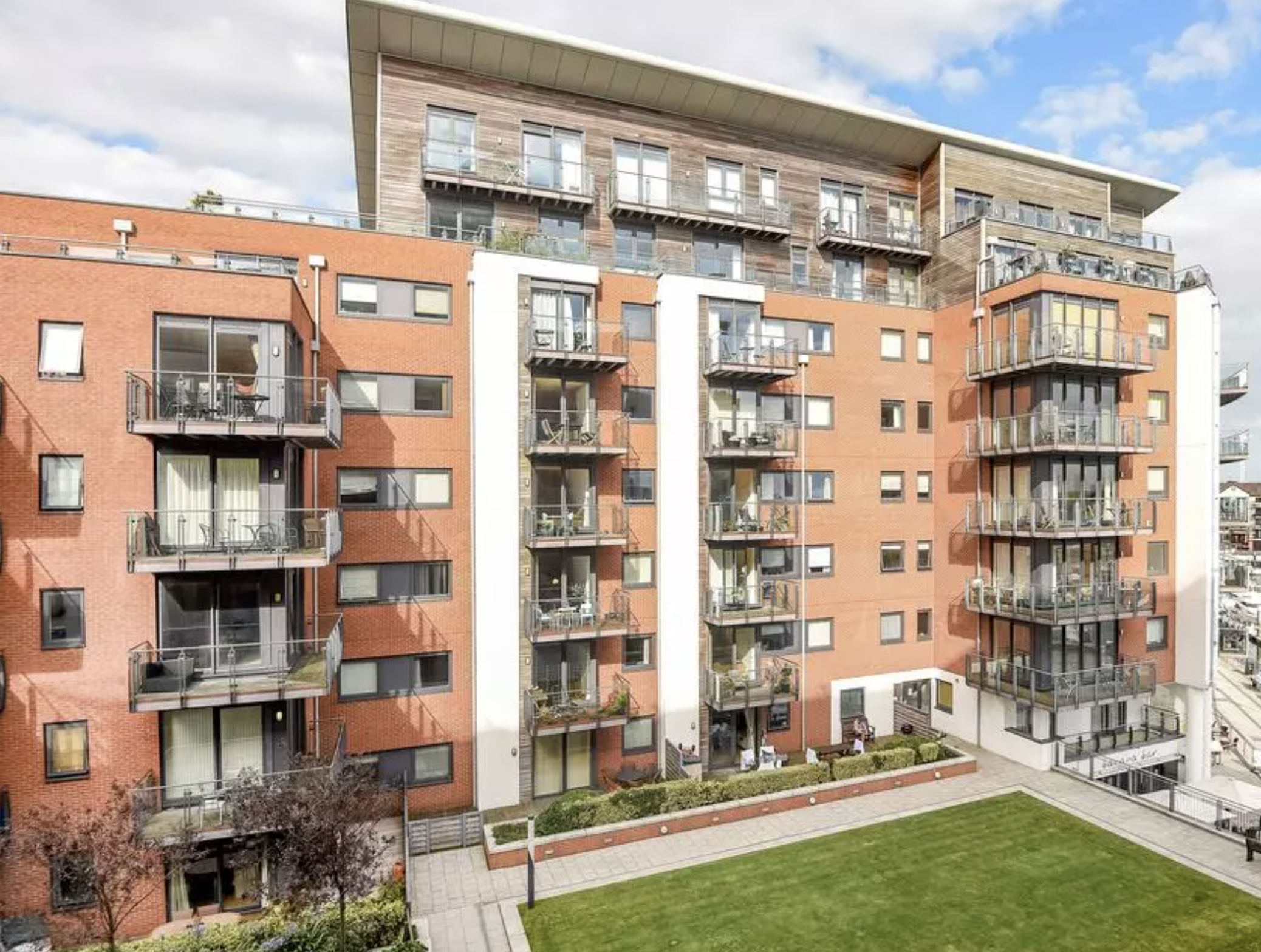 The Blake Building, Southampton: brick and timber-clad residential block with balconies above a landscaped courtyard