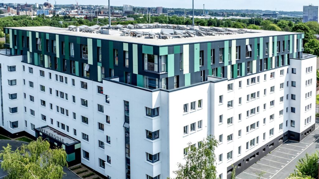 The Greenhouse, Leeds: aerial view of the white apartment block with its green and teal top floor