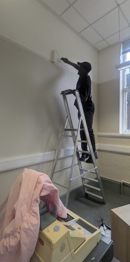 Painting from a stepladder during the Women’s Whispers office refurbishment in Leeds